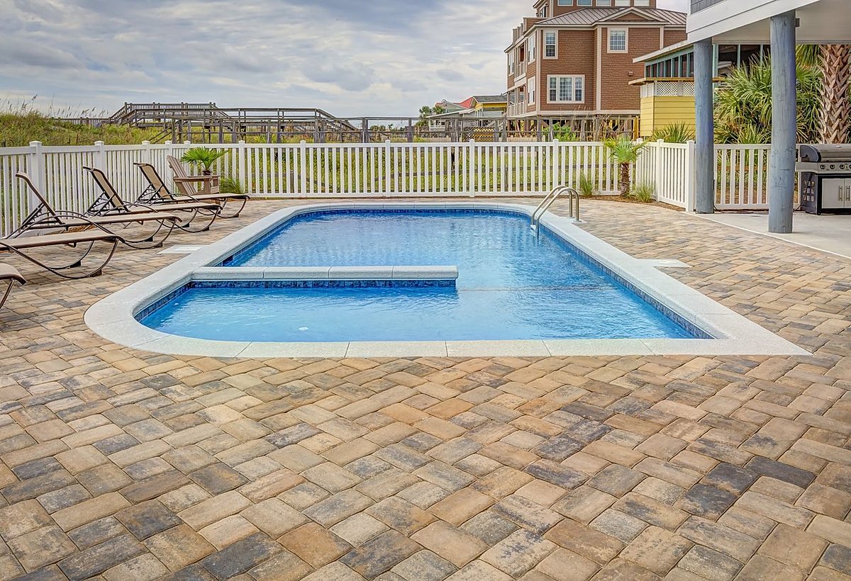 A newly built residential pool with paver decking